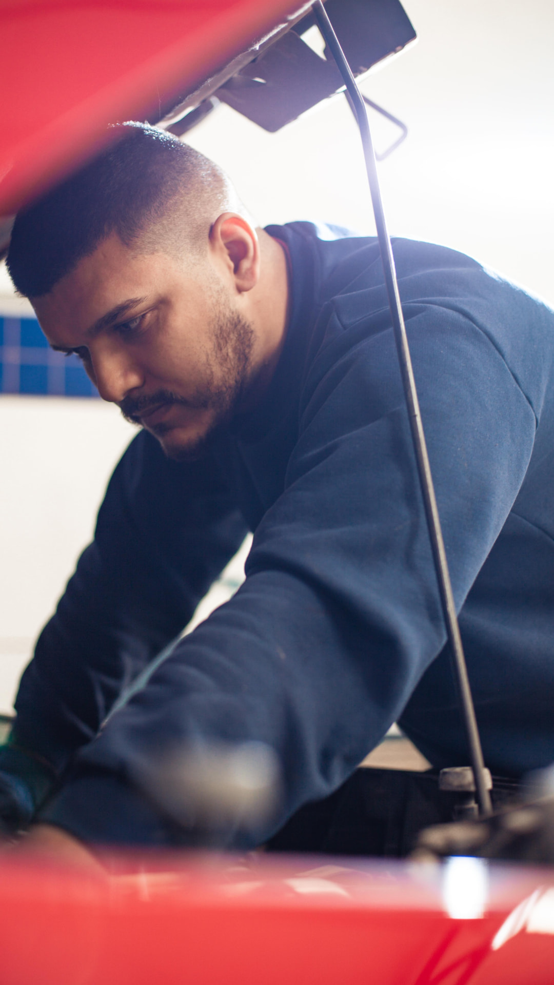 Mecânico da Garra Auto Center inspecionando o motor de um veículo